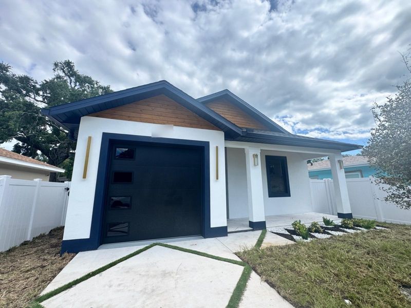 Newly built custom home in Tampa, Florida, with a navy garage door and cedar gable accents