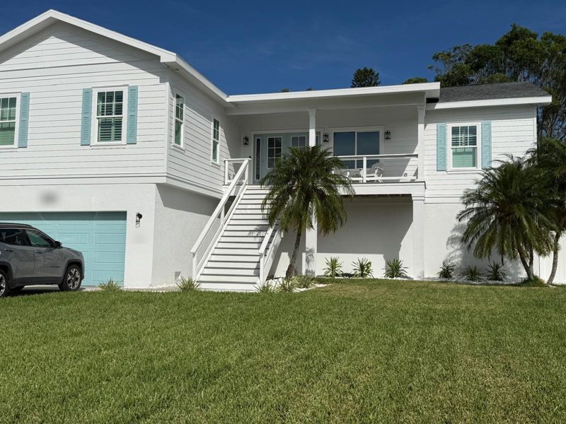 Raised coastal home in St. Petersburg, Florida, rebuilt with a second story after flooding
