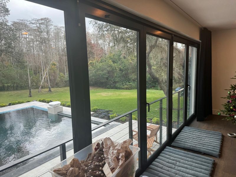 Floor-to-ceiling windows looking out over a pool and lawn in Tampa, Florida