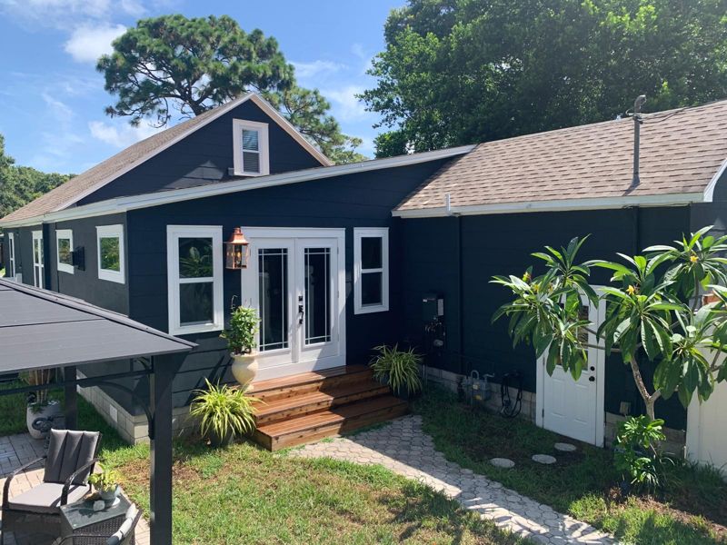 Navy-blue home addition with French doors and a timber entry step in St. Petersburg, Florida