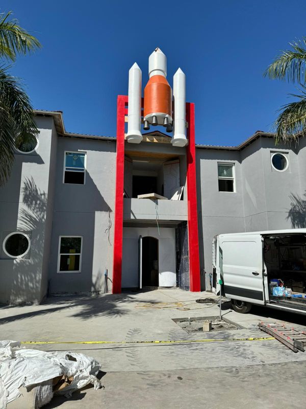Rocket and twin boosters on a red reinforced concrete frame above the entrance of the Mission to Mars themed estate in Davenport, Florida