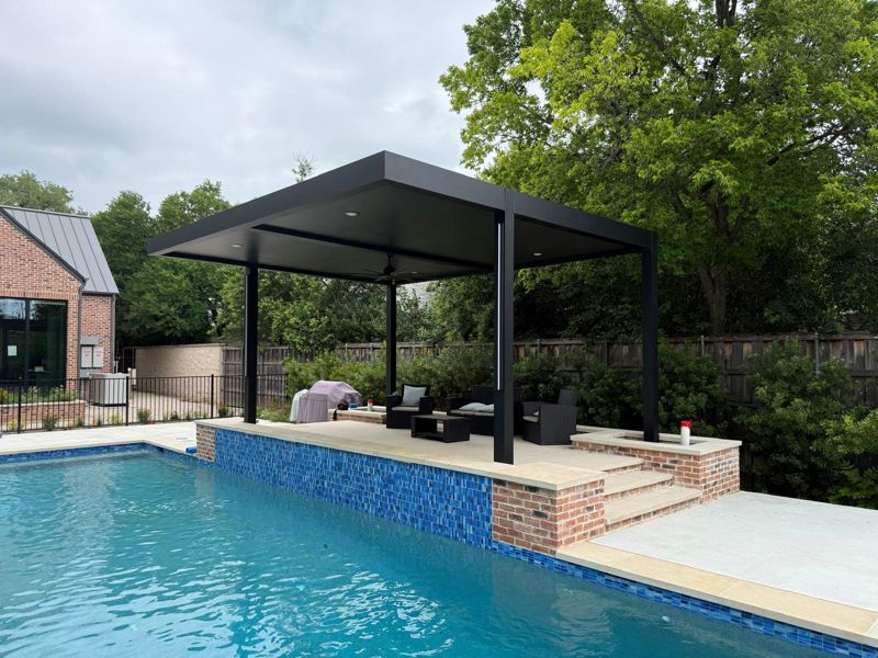 Black modern pergola on a raised deck beside a pool in Austin, Texas
