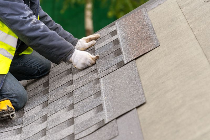 Roofer installing shingles